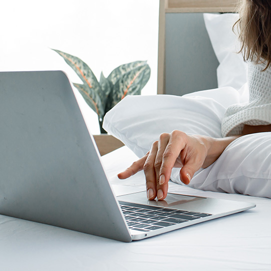 Eine Dame bucht auf einem Laptop einen Hotelaufenthalt